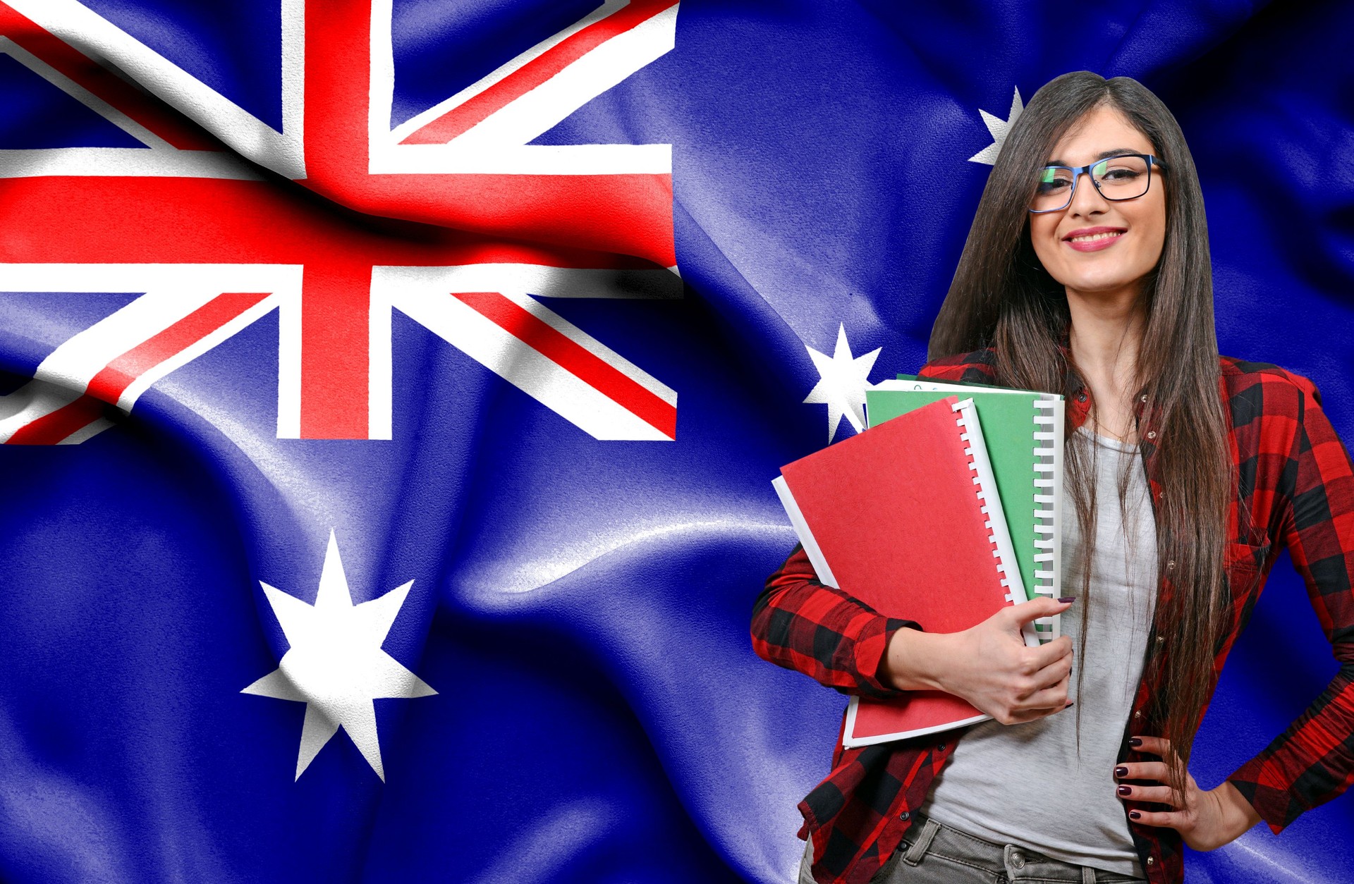Happy female student holdimg books against national flag of Australia