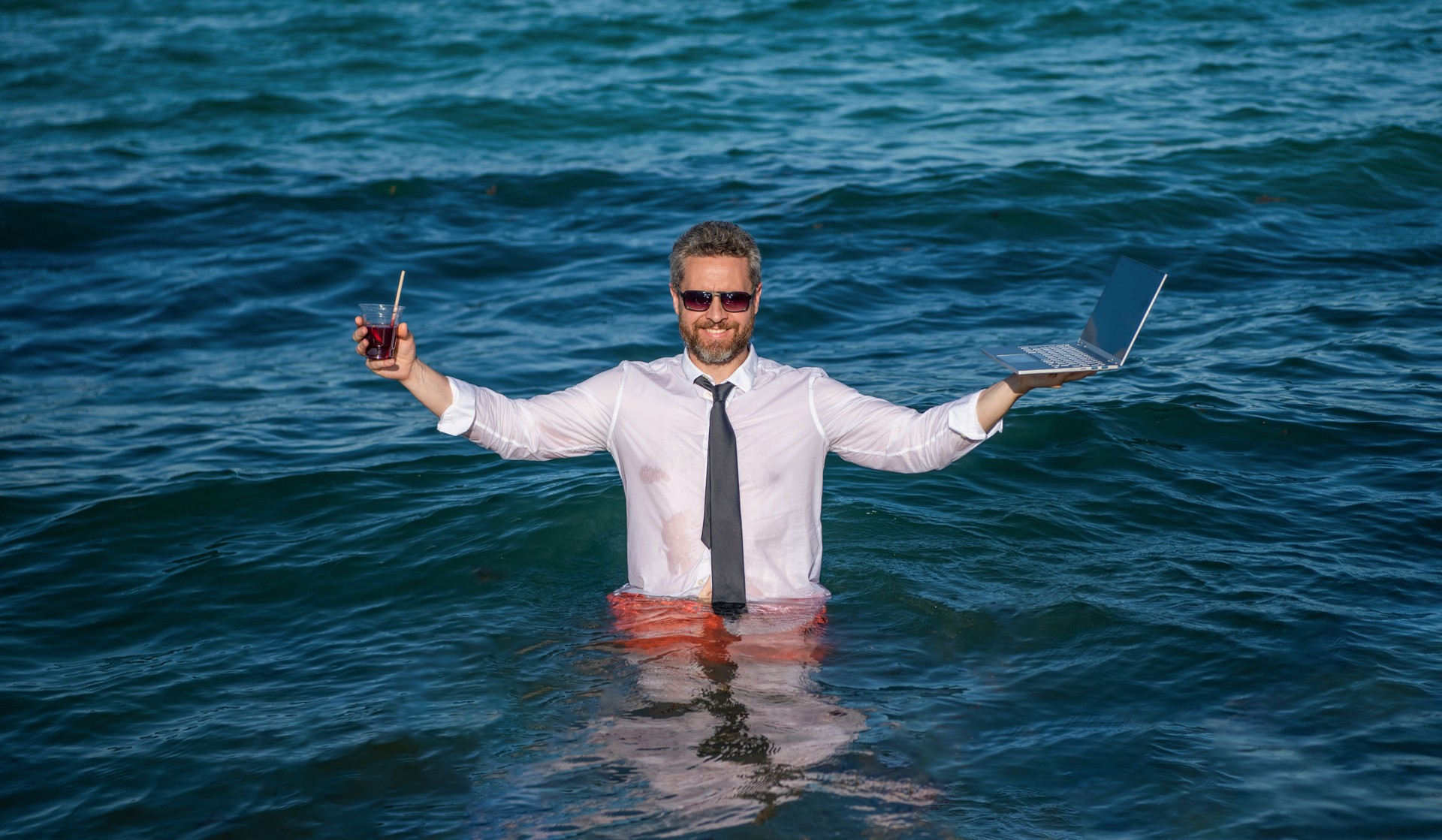 Man freelance worker online. Successful business. Businessman in summer sea. Online freelance work. Businessman office worker with laptop. Business man in sea with laptop. Travel and business